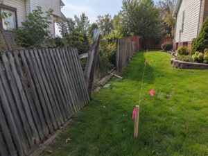 Boundary survey in Fairfax VA showing marked property lines beside an old fence before replacement.